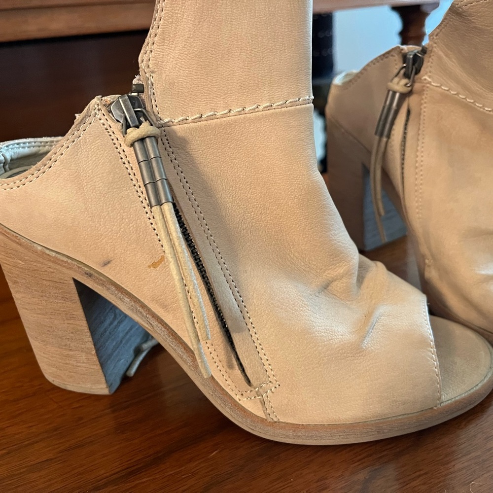 Cream rawhide leather wide heel open toe and heel shoe with zippers on sides.